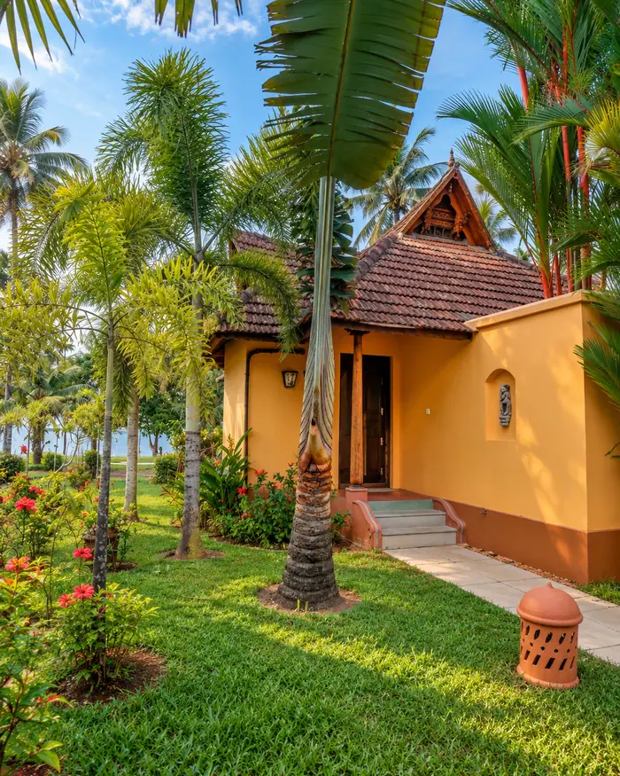 Ananda's tiled gable and ochre walls behind a palm-shaded lawn
